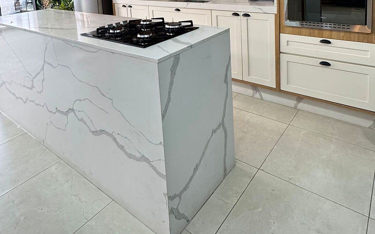 Detalhe da ilha da cozinha em quartzo com veios acinzentados